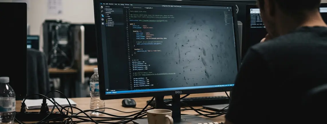 IDE or code editor with syntax highlighting, screen glare across a dark theme, fingerprints